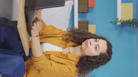 Vertical-video-of-Young-woman-looking-at-laptop-is-unmotivated-and-bored.